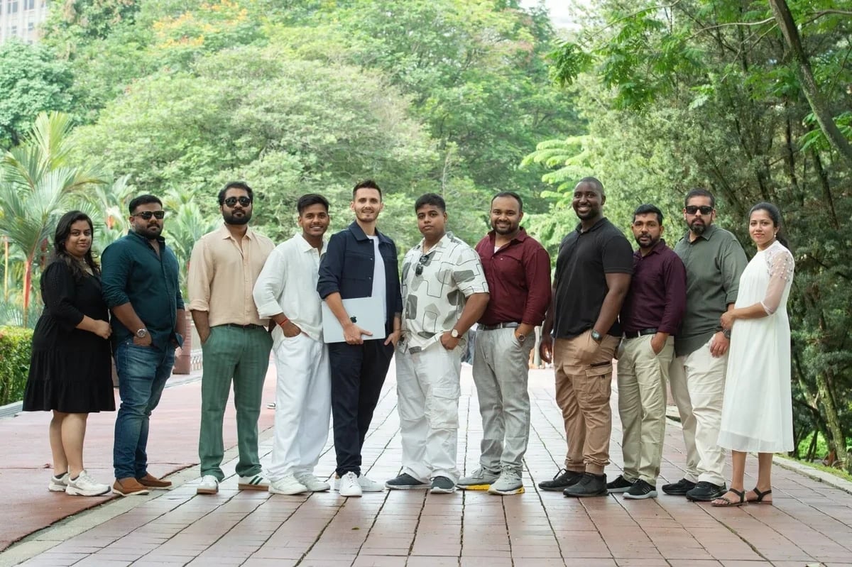 The Mr Digital team, thirteen people standing together on a tree-lined path